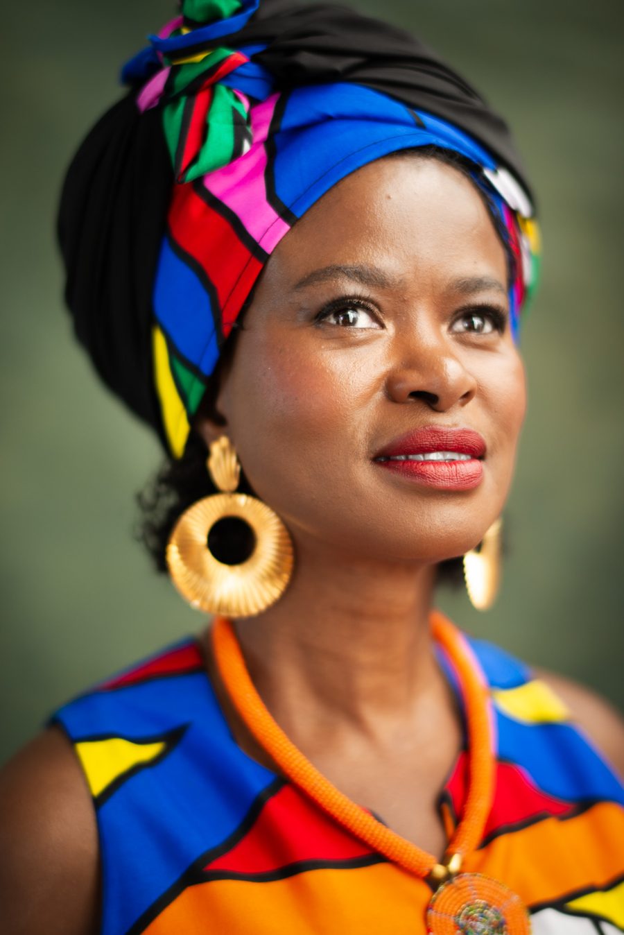 Tae Betty, Sangoma, looking sideways and upward — portrait in a traditional headscarf